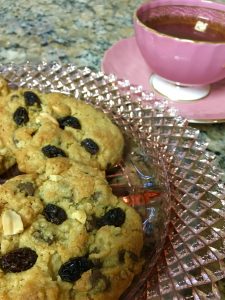 Cookies on plate next to full teacup